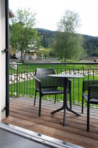 a patio with two chairs and a table on a deck at Casa Montana in Commezzadura