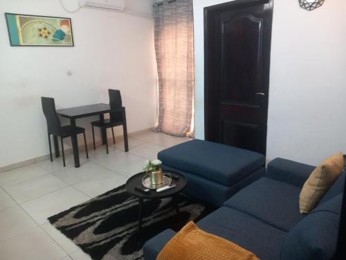 a living room with a blue couch and a table at Services Meublé in Douala