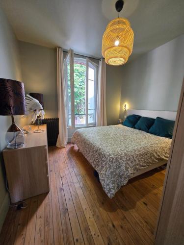 une chambre avec un lit et une grande fenêtre dans l'établissement Villa Rova, à Vichy