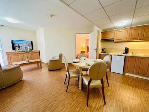 une pièce avec une table et des chaises et une cuisine dans l'établissement T2 à proximité Grands Buffets, à Narbonne