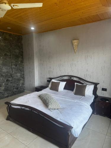 a bedroom with a large bed with white sheets and pillows at The Ivyview Villa Kumarhatti Barog Near Kasauli in Barog