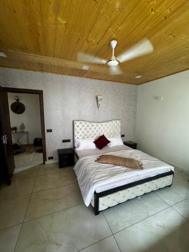 a bedroom with a bed with a wooden ceiling at The Ivyview Villa Kumarhatti Barog Near Kasauli in Barog