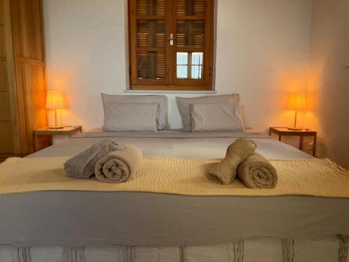 a bedroom with a bed with towels on it at Bright Cozy Home with Terrace, Garden & Sea View in Neokhórion