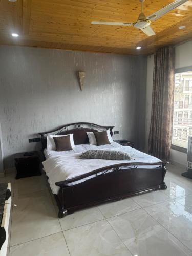 a bedroom with a large bed with a wooden ceiling at The Ivyview Villa Kumarhatti Barog Near Kasauli in Barog