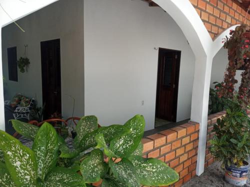 a brick wall with a door and some plants at Garden House - Atins in Atins