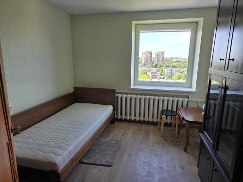 a small room with a bed and a window at Apartaments Kaunas in Kaunas