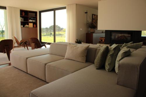 a living room with a white couch and a fireplace at Lusus Wine House in Lourosa
