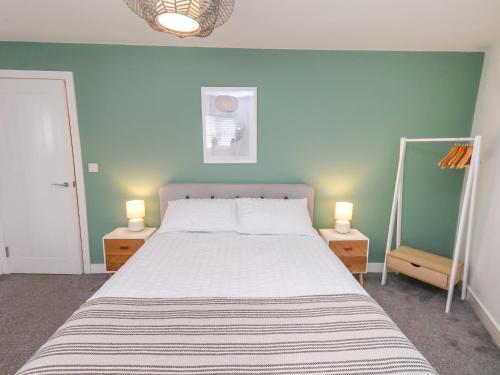 a bedroom with a bed and two night stands with two lamps at Glenholme Apartment 3 in Redcar