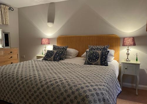 a bedroom with a large bed with pillows at Stylish 1-bed Cottage Escape in Piddlehinton in Piddlehinton