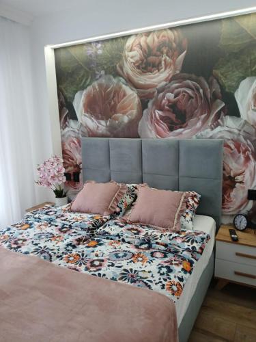 a bedroom with a large painting of flowers on the wall at Casa Barcelona 2 minutos la playa in Cullera