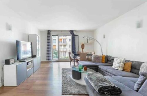 un salon avec un canapé et une télévision dans l'établissement Majestic Luxueux 2 big Bedroom Eiffel-Tower, à Paris