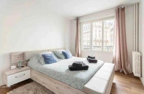 - une chambre avec un grand lit doté d'oreillers bleus et d'une fenêtre dans l'établissement Majestic Luxueux 2 big Bedroom Eiffel-Tower, à Paris