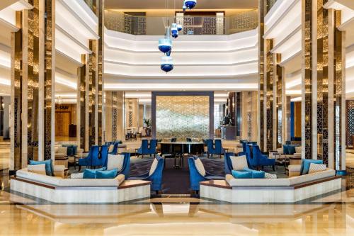 a lobby with blue chairs and a table at The Diplomat Radisson Blu Hotel Residence & Spa in Manama