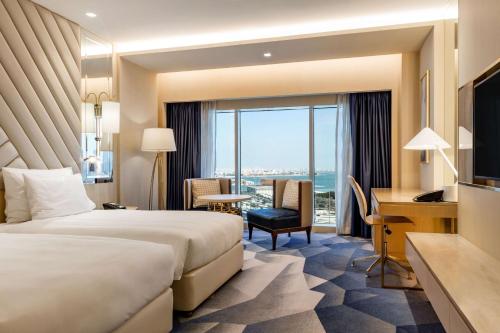a hotel room with a bed and a desk at The Diplomat Radisson Blu Hotel Residence & Spa in Manama