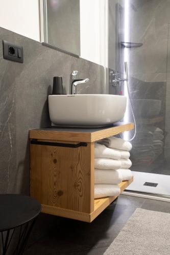 a bathroom with a sink and a pile of towels at Casa Montana in Commezzadura