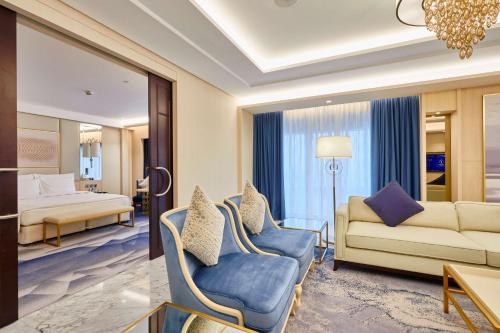 a living room with a couch and a bed at The Diplomat Radisson Blu Hotel Residence & Spa in Manama