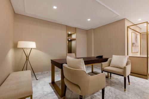 a room with a table and chairs and a mirror at The Diplomat Radisson Blu Hotel Residence & Spa in Manama