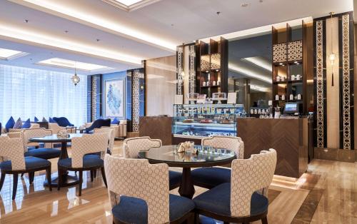 a restaurant with tables and chairs and a bar at The Diplomat Radisson Blu Hotel Residence & Spa in Manama