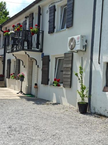 a white building with flower boxes on the windows at Kameni biser in Jurdani