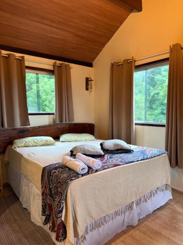 a bedroom with a large bed with towels on it at Bangalô império verde in Chã Grande