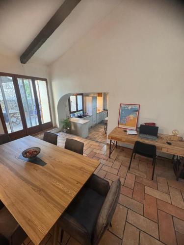 un salon avec une table et des chaises en bois dans l'établissement Maison traditionnelle Gardoise avec Jacuzzi 5 personnes 3 chambres, à Saint-Laurent-des-Arbres