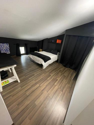 une chambre avec un lit et un parquet dans l'établissement Maison traditionnelle Gardoise avec Jacuzzi 5 personnes 3 chambres, à Saint-Laurent-des-Arbres
