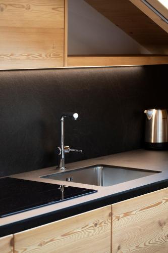 a kitchen with a sink and a black wall at Casa Montana in Commezzadura
