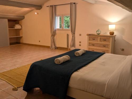 une chambre avec un grand lit avec deux serviettes dessus dans l'établissement Villa Piscine et Nature Cévenole, à Molières-sur-Cèze