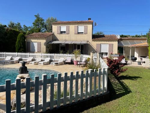 une clôture blanche devant une maison dans l'établissement Villa de caractères,piscine, vue sur le luberon,3 chambres, à Cheval-Blanc