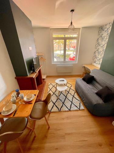 un salon avec une table et un canapé dans l'établissement Amiens Hortillonnages Studio, à Amiens