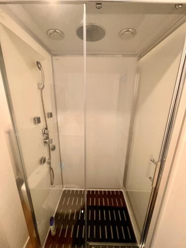 une douche avec une porte vitrée dans une salle de bain dans l'établissement Amiens Hortillonnages Studio, à Amiens