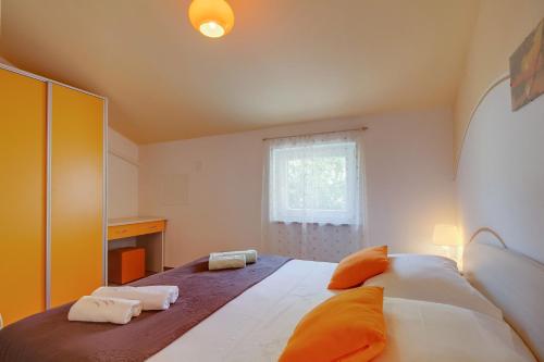 a bedroom with a large bed with orange pillows at Apartment Jasna Near Čikat Bay and Center with Private Parking in Mali Lošinj