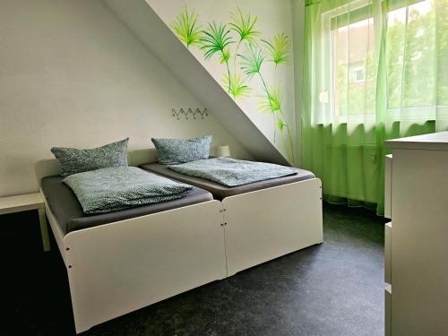 Una cama con dos almohadas encima en una habitación. en City-Apartment, en Sinsheim