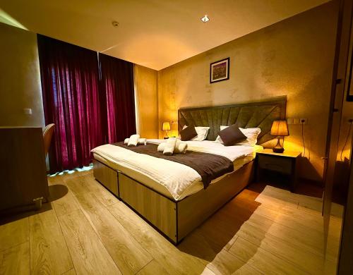 a bedroom with a large bed and red curtains at New York Palace Tashkent in Yakkasaray