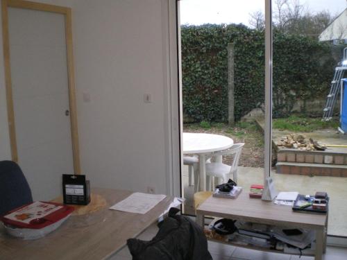 - un salon avec une table et une vue sur la cour dans l'établissement Location neuve, à Croix-Chapeau