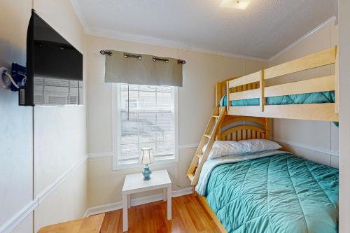 a bedroom with a bunk bed and a television at Assateague Pointe - Longboat in Berlin