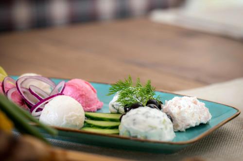 a plate of food with vegetables on a table at Snezhanka Hotel Pamporovo-All inclusive & Half Board in Pamporovo