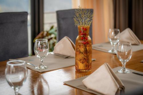 a wooden table with glasses and a vase on it at Snezhanka Hotel Pamporovo-All inclusive & Half Board in Pamporovo