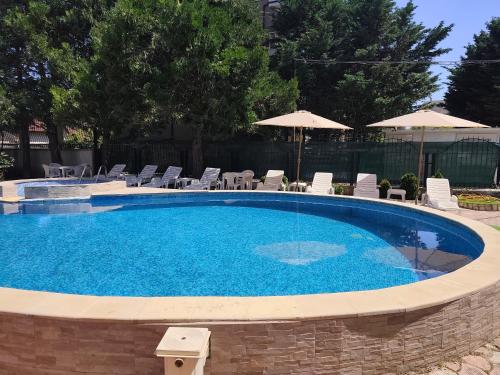 a large swimming pool with chairs and umbrellas at Bo's place in St. St. Constantine and Helena