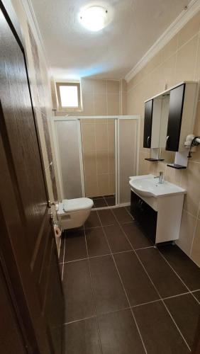 a bathroom with a sink and a tub and a toilet at Akın Turunç Pansiyon in Marmaris