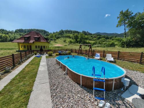 uma piscina num quintal com uma casa em Šarganska Idila em Mokra Gora
