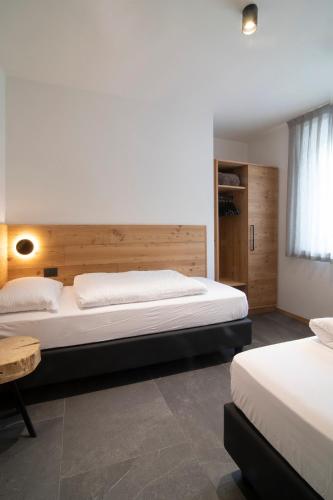 a bedroom with two beds and a wooden headboard at Casa Montana in Commezzadura