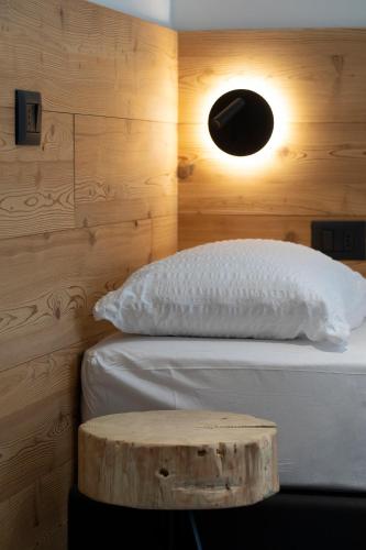 a bedroom with a bed with a wooden wall at Casa Montana in Commezzadura