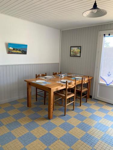 une salle à manger avec une table et des chaises en bois dans l'établissement Appartement La Faute sur mer proche plage RDC, à L'Aiguillon-la-Presqu'île