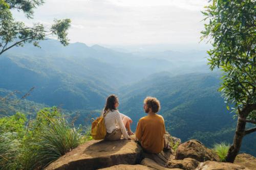 エッラにあるTalblick Homestay Ellaの谷を見下ろす岩の上に座っている二人