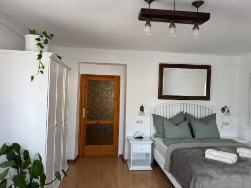 a bedroom with a bed and a wooden floor at GaLiBa Vendégház in Jenő