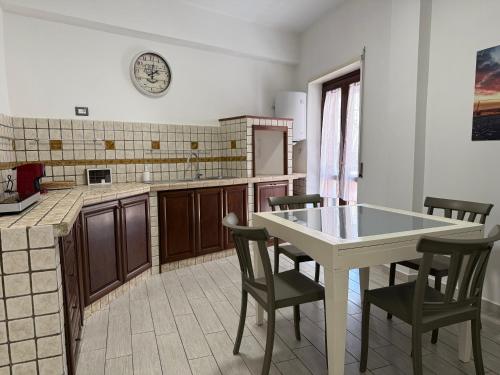 a kitchen with a table and chairs and a clock on the wall at Maison du port 2 in Civitavecchia