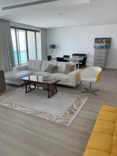 a living room with a white couch and a table at Luxe Private Beach Apartment Residence in Sharjah