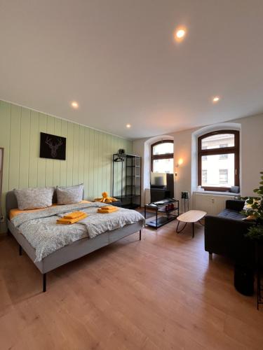 a bedroom with a large bed and a living room at Makro Apartment Großenhain in Großenhain