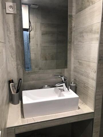 une salle de bain avec un lavabo blanc et un miroir dans l'établissement Cozy apartment in downtown Montpellier, à Montpellier